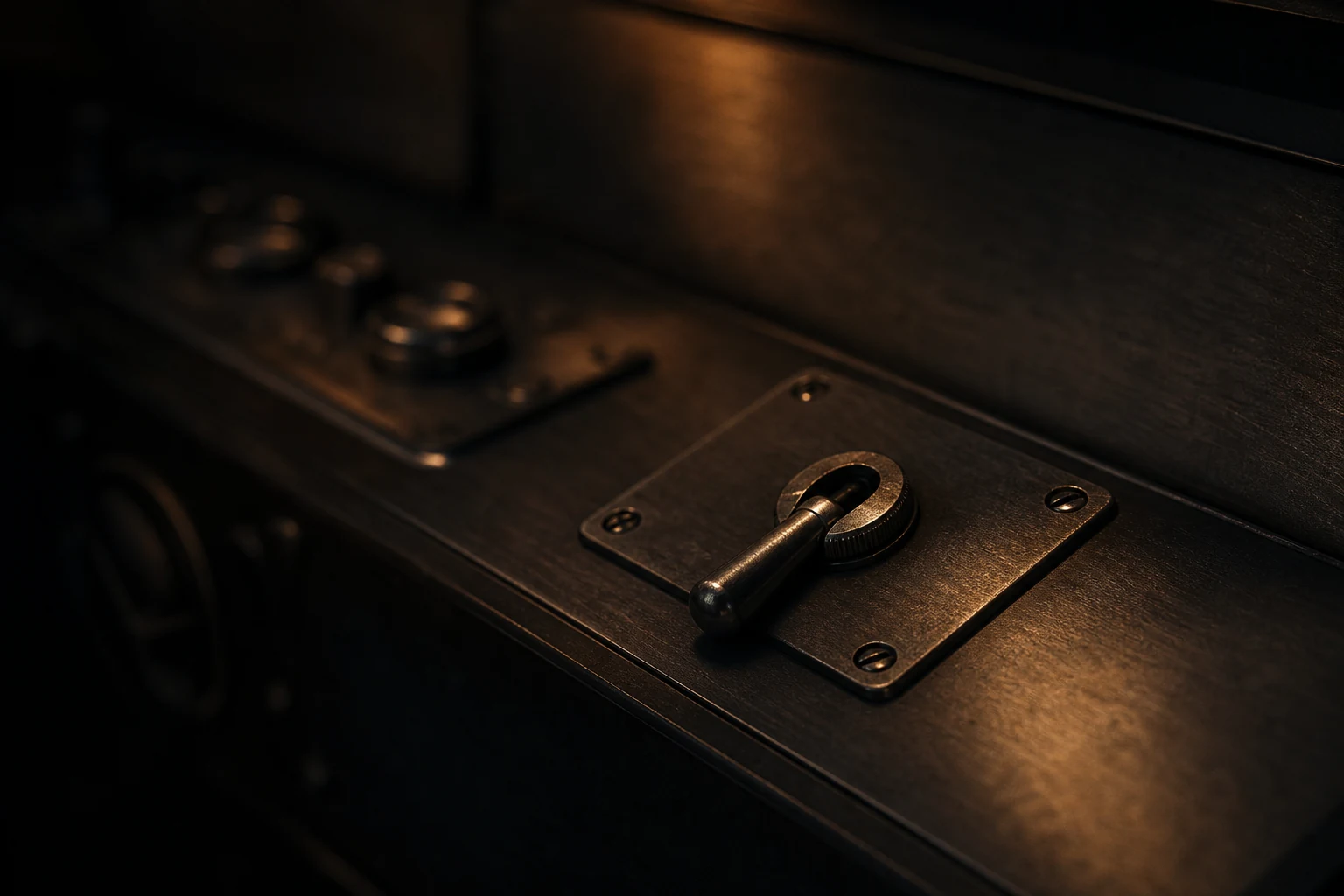 Heavy industrial switch in the off position, isolated in raking light on a darkened control desk