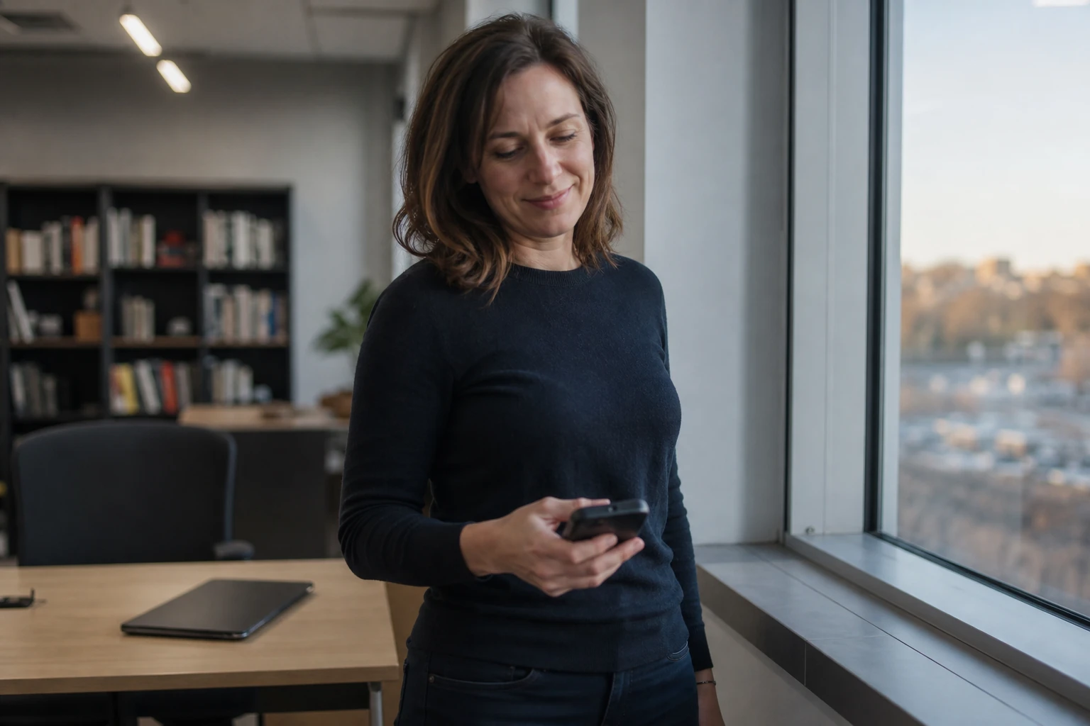 An ordinary office worker glancing at a phone by a window in the late afternoon, deciding not to tap through to a website
