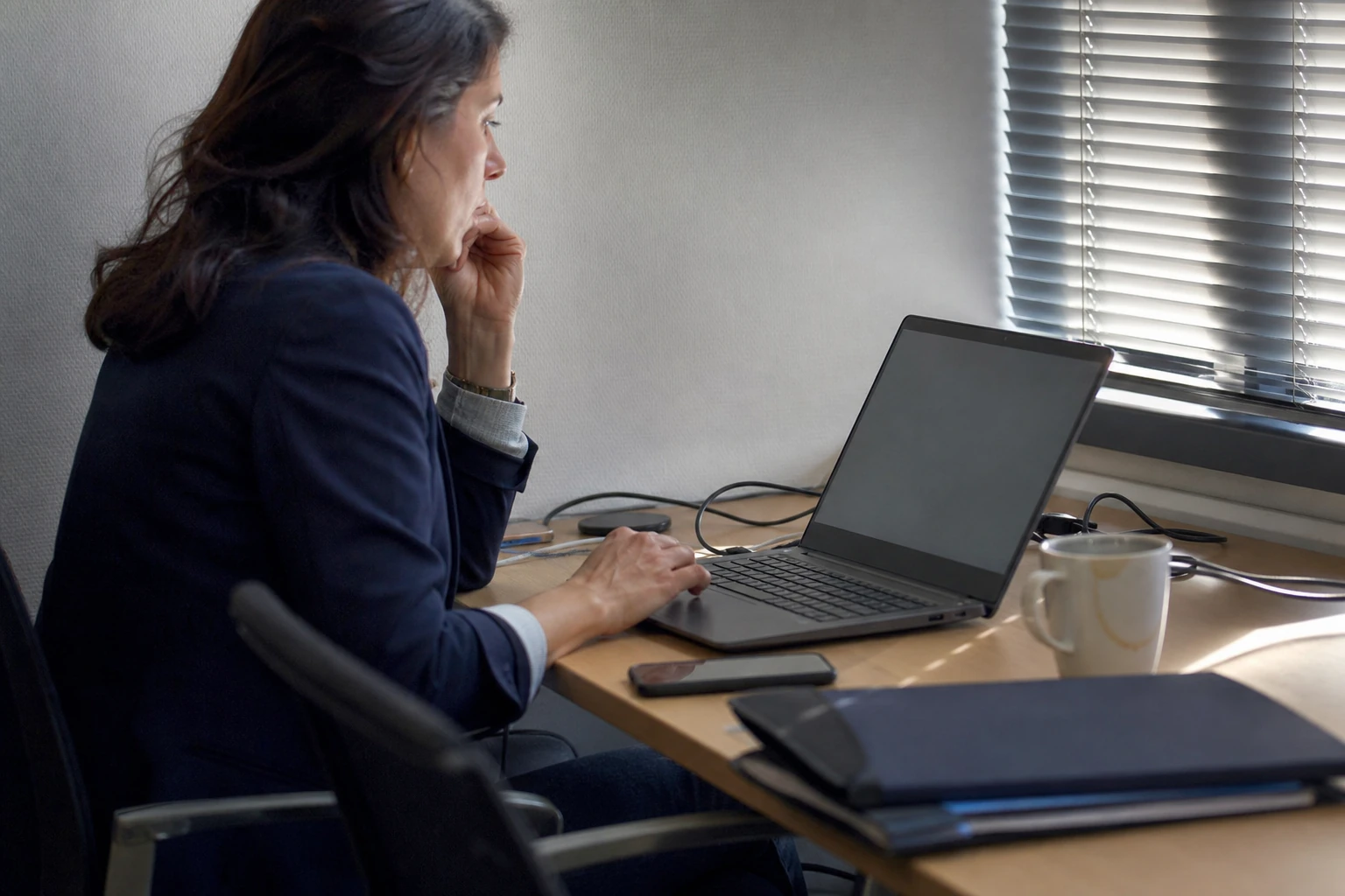 Analyste marketing relisant un contenu sur un ordinateur portable dans un bureau, illustrant le suivi de la fraîcheur d'une page pour les moteurs IA